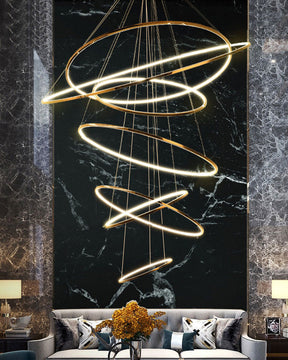 Glowing entryway chandelier against a dramatic black marble wall, turning an oversized vertical space into a luxurious first impression.