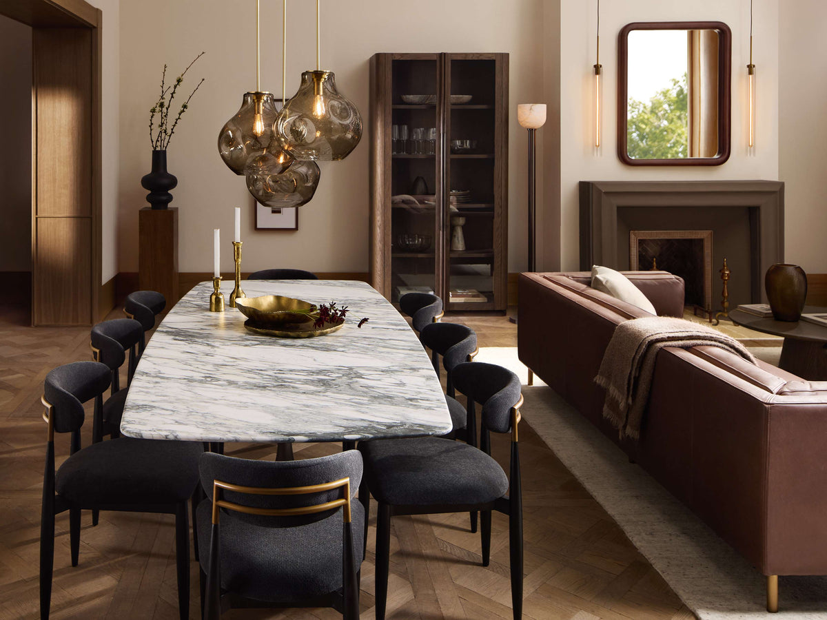 Organic 12" Pendant with smoky gray mouth-blown glass shade, brass fitting, glowing Edison bulb, black cord, hanging.