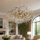 An antique brass branch chandelier adorned with hanging teardrop and icicle crystal pendants against a soft background.